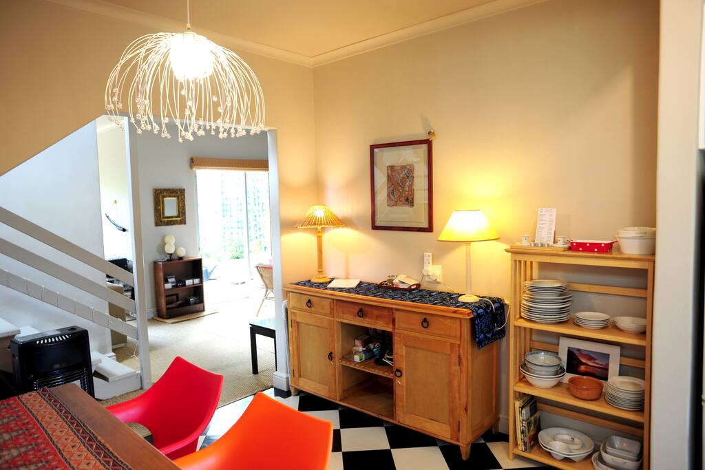 Looking out from the kitchen towards the living room and up the stairs to the bedrooms. Oregon pine dresser and shelving with the crockery