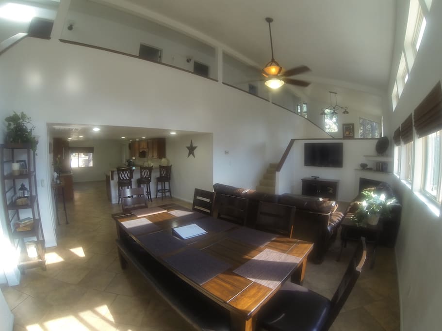 Great room with farmhouse dining table, leather couches, and open to the kitchen