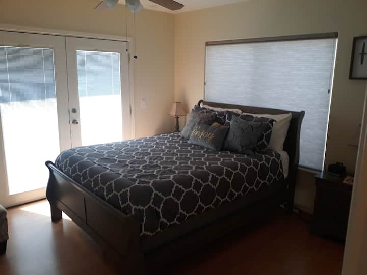 غرفة نوم تطل على الفناء ومنطقة حمام السباحة.