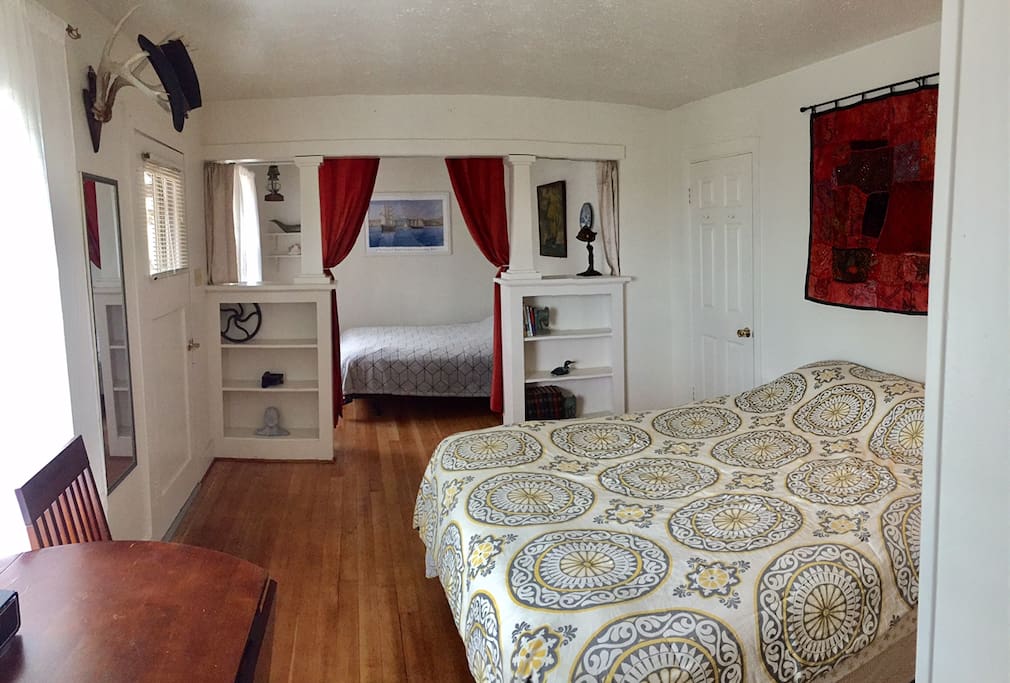 Large bedroom with built-in shelving, refinished original hardwood