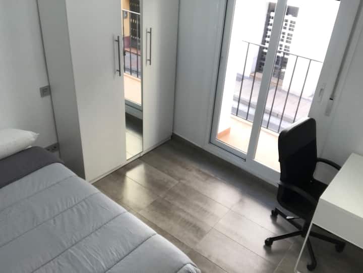 房间明亮，配有椅子和书桌