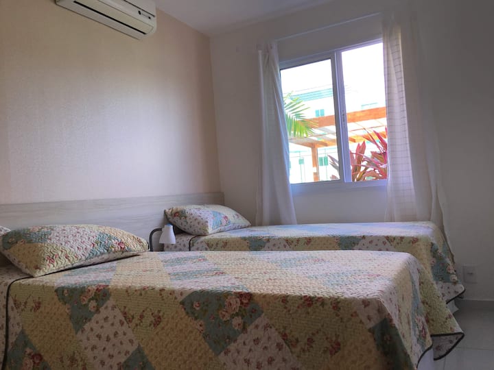 Dormitorio individual con camas individuales, aire acondicionado y armario.