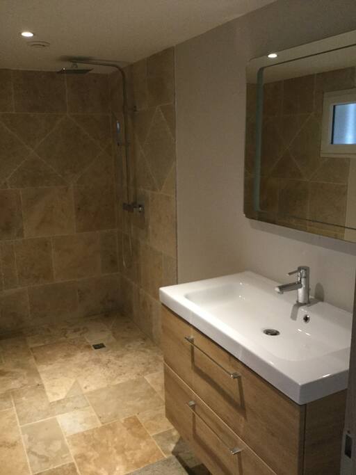 Grande salle d'eau, avec une une belle douche à l'italienne en pierre naturelle.