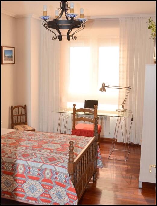 Habitación individual con cama de 1.05, armario, estantería, mesa de estudio y televisión.