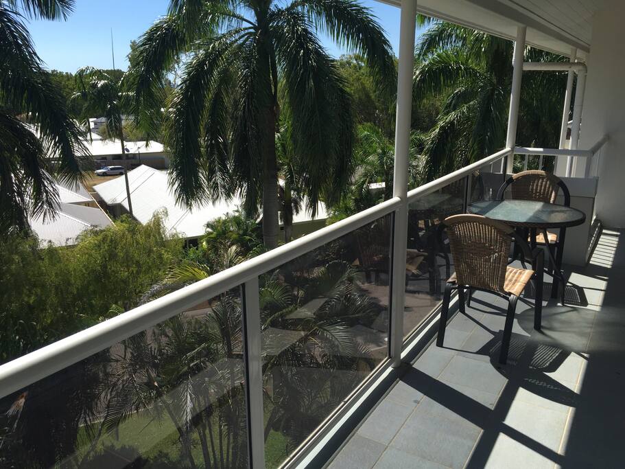 Balcony with dining table and view s across the tropical gardens