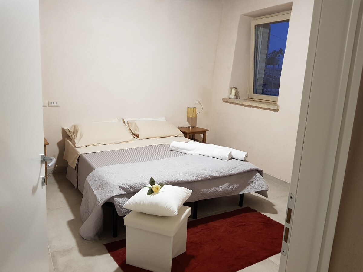 Una habitación doble amueblada con conceptos modernos que destacan la estructura de la granja restaurada con técnicas de construcción verdes que conservan su valor histórico y natural a la vez que garantiza una higiene y limpieza perfectas.