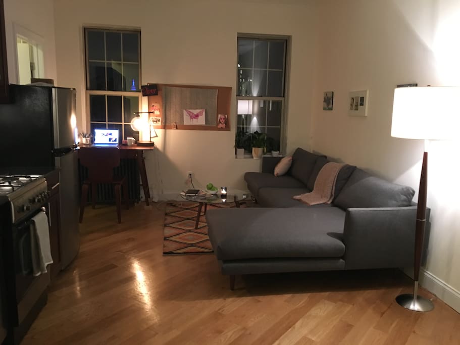 Living room at night with view of Empire State Building from window/fire escape
