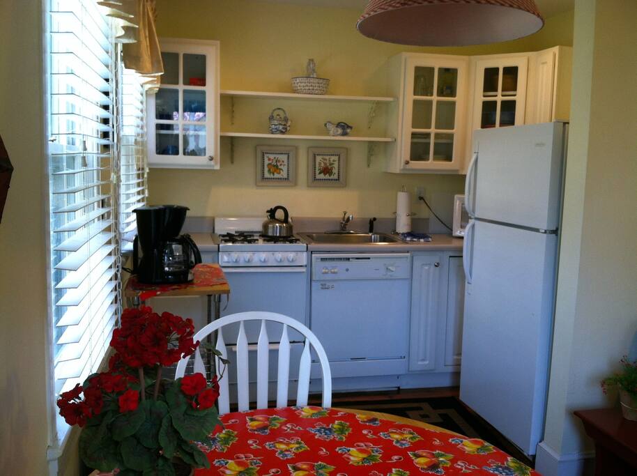 View of fully equipped galley kitchen, table and chairs