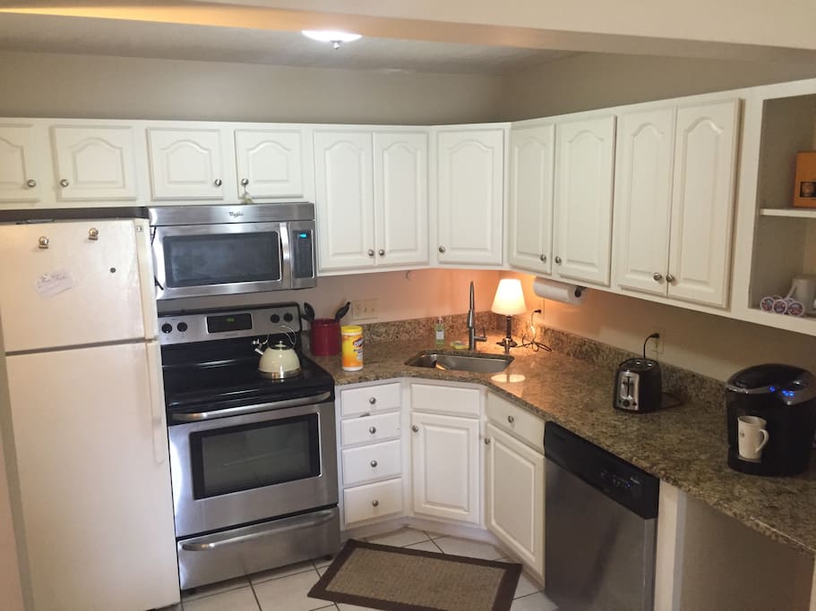 Downstairs kitchen with stove, oven, microwave, fridge, coffee machine, toaster, and the dishwasher.