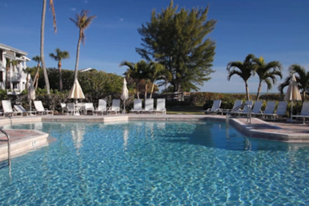 Modern pool and hot tub with plenty of lounge chairs