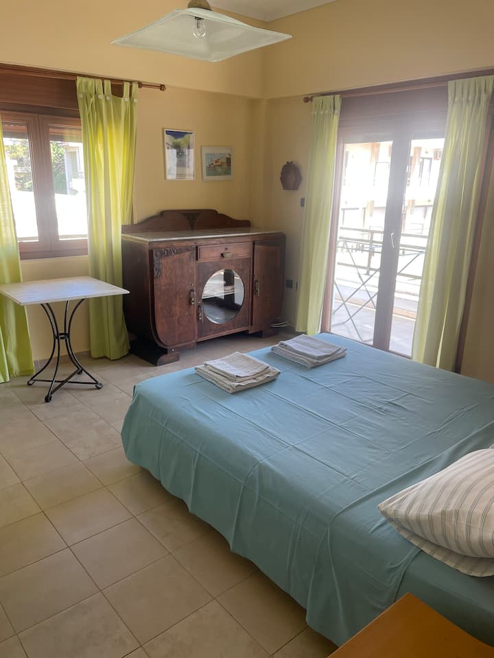 Dormitorio principal con cama tamaño king, dos armarios grandes y un aparador. Acceso al balcón.