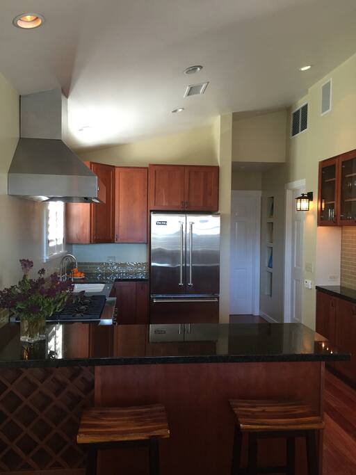 Chef's kitchen with Viking appliances, and granite counters, including breakfast bar and fully stocked. Open floor plan to the living room and dining room