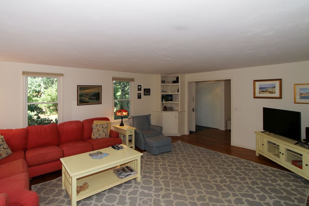 Sectional that seats 7, 42" TV and comfortable chairs. Directly off of main hall, connects to dining room.