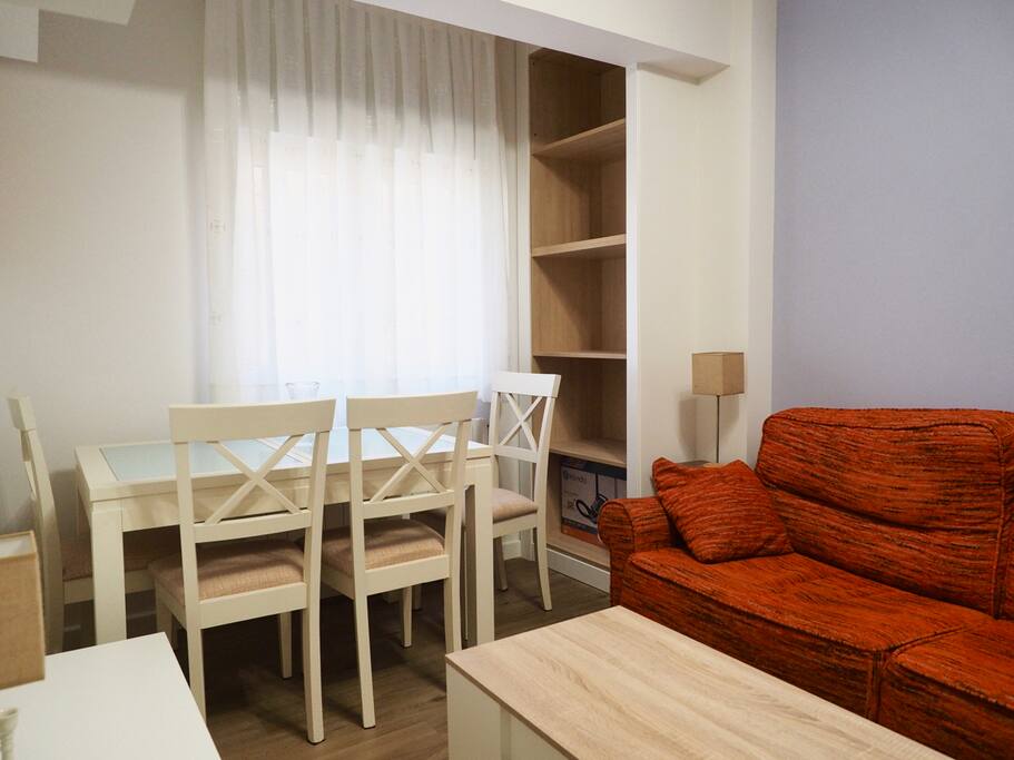 Salón acogedor con televisión, sofá y mesa