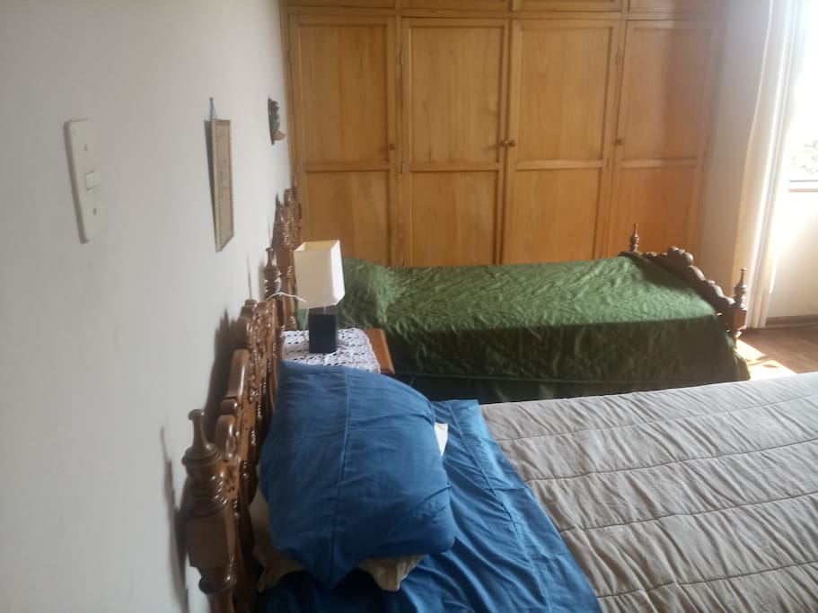 Dormitorio con dos camas de plaza y media tocador y closet