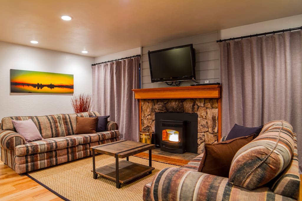 Spacious lounge room with wood floors and fireplace