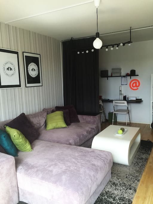 The living room with a huge sofa (can be a bed-sofa, 140cm wide) and two small writing desks.
