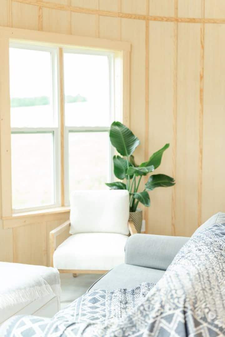 The small living space is comfy with two chairs, loveseat, and ottoman. 