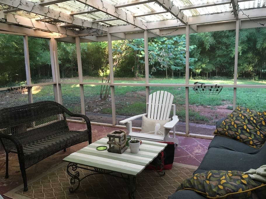 Screened in porch out back with mounted tv (cable), view of private backyard, perfect for enjoying sunsets and morning coffee