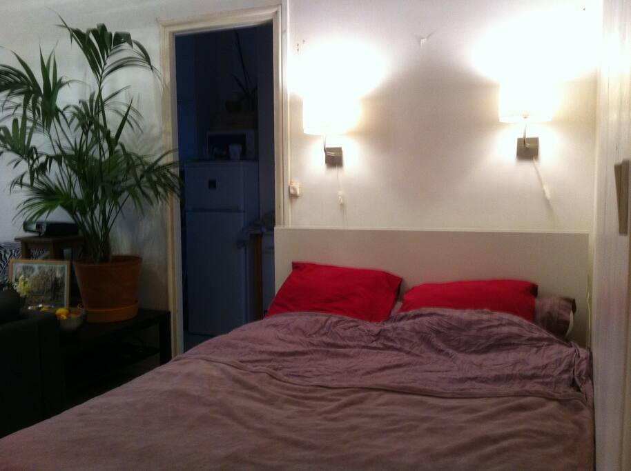 Lit deux places avec matelas ferme et liseuses.