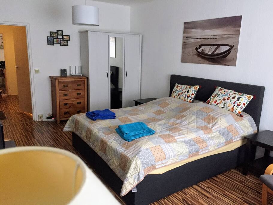 The living room has an XXL bed with all utilities like towels, bed linen, several pillows, and additional blankets.