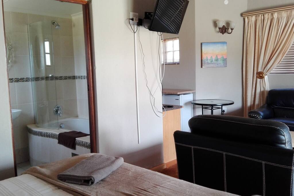 Lounge with kitchenette TV small fridge and basic utensils.