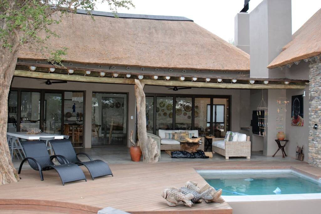 Outdoor patio, pool, outdoor dining table and lounge area.