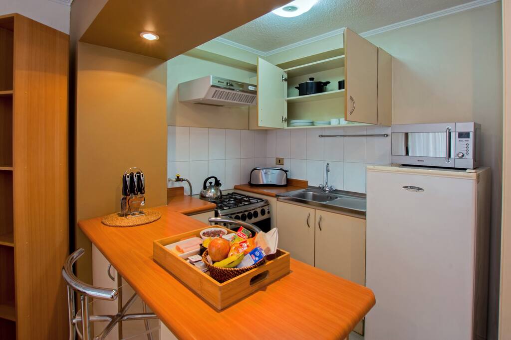 Cocina con refrigerador, microondas y tostadora