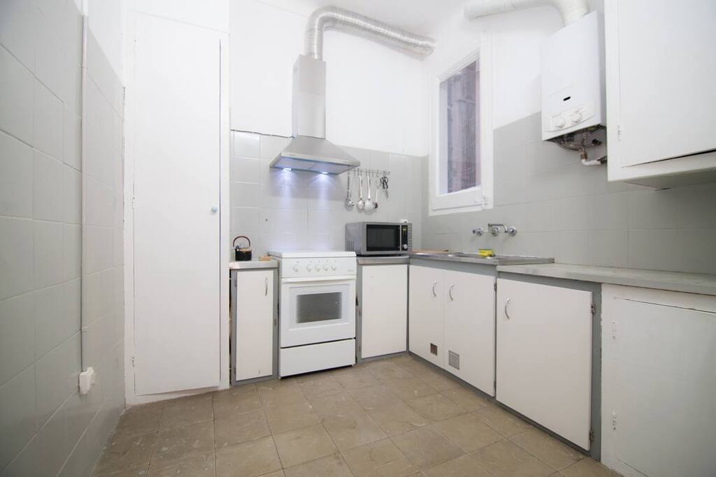 Cocina con refrigerador, horno, microondas, cafetera.