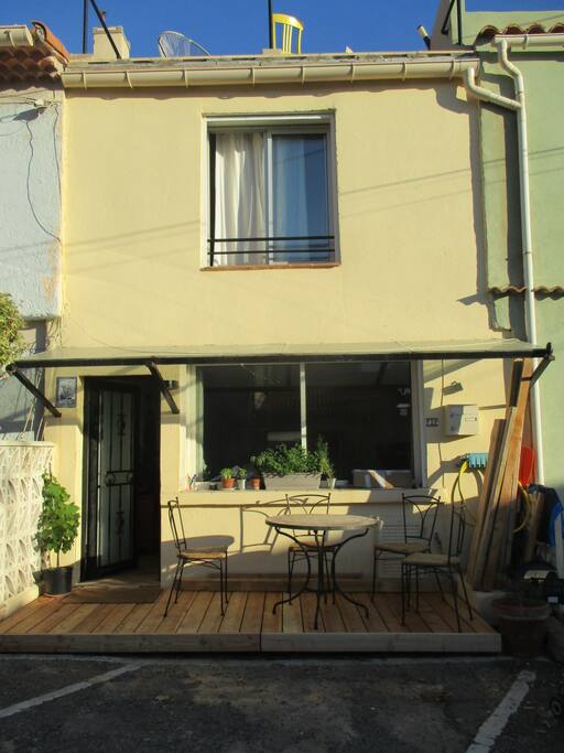 petite terrasse en bois devant l'entrée pour profiter de la fraîcheur.