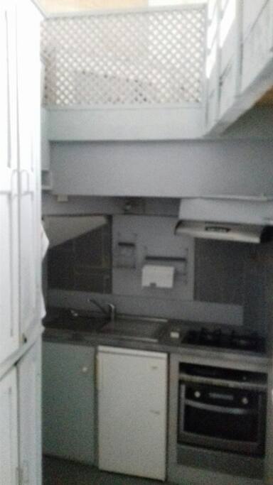 cuisine à mi étage équipée d'un four qui fait aussi micro ondes, d un réfrigérateur et d' une plaque de cuisson gaz 2 feu