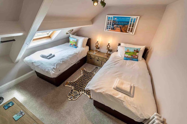 Manja (ali jednako lijepa) spavaća soba u potkrovlju, s dva odvojena kreveta koji se mogu povezati kako bi se stvorio super-kraljevski krevet. Molimo vas da nas obavijestite o svojim željama prilikom rezervacije. S ogledalima u prozorima, industrijskom ogradom za viseće cijevi, kukama za jastoge i pogledom na opatiju.