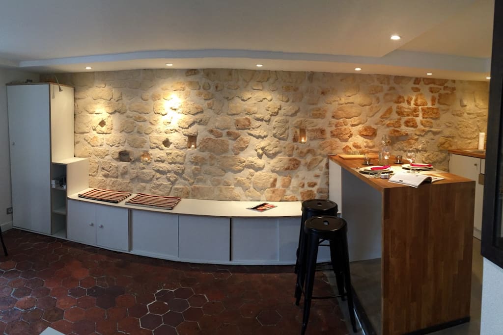 Le mur en pierres apparentes s'éclaire de façon modulable. On peut insérer des bougies dans les niches naturelles