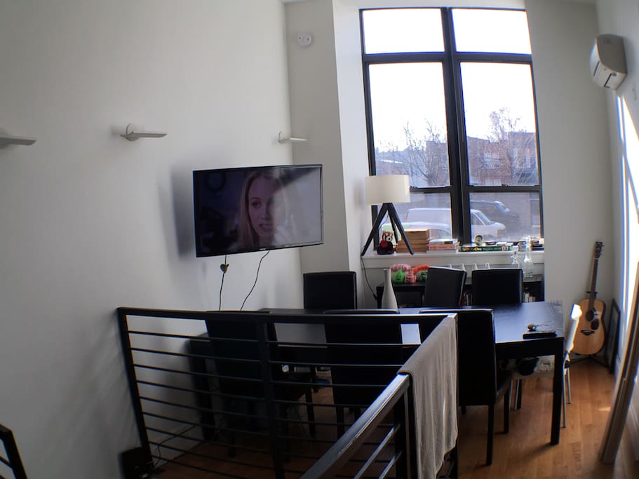 The dinning room with tv and lots of light and high cielings