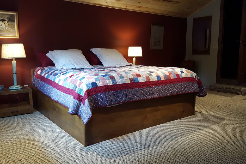 The upstairs bedroom is a loft and features a king size bed and access to the bathroom.