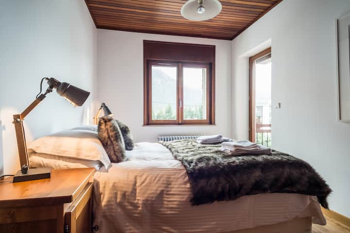 להירגע במיטה עם נוף יפהפה של הר בלאן וגישה למרפסת הגדולה.  חדר שינה 1.