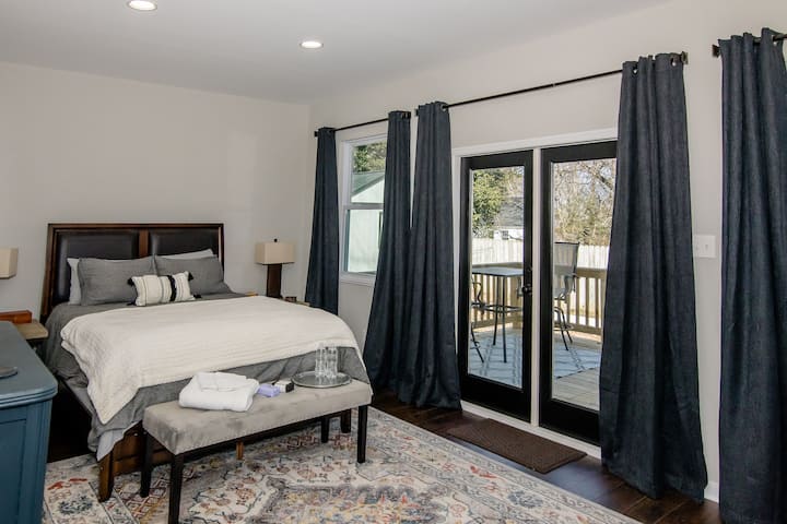 ห้องนอนกว้างขวางพร้อมเตียงควีนไซส์ที่สะดวกสบายทีวีหมอนเสริมและผ้าม่านกันแสง