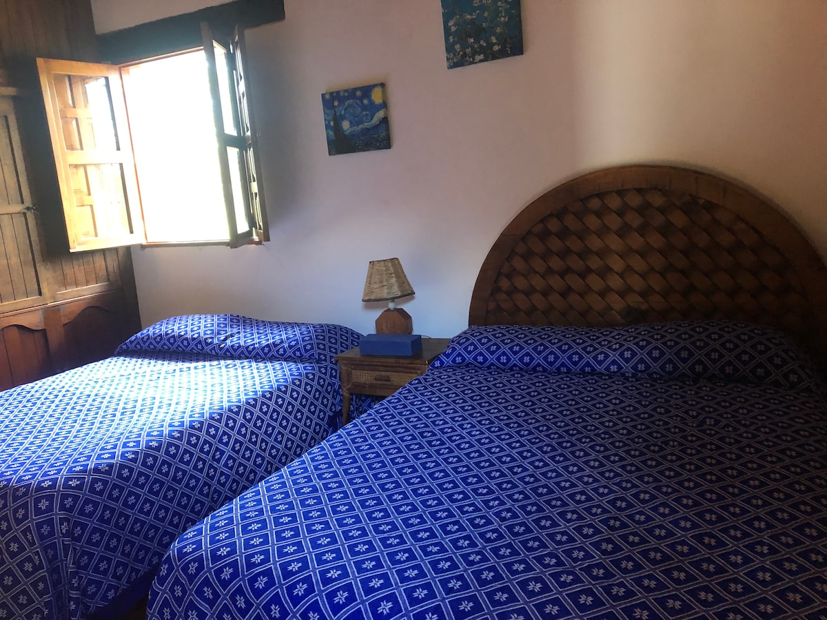 Spavaća soba s dva bračna kreveta.