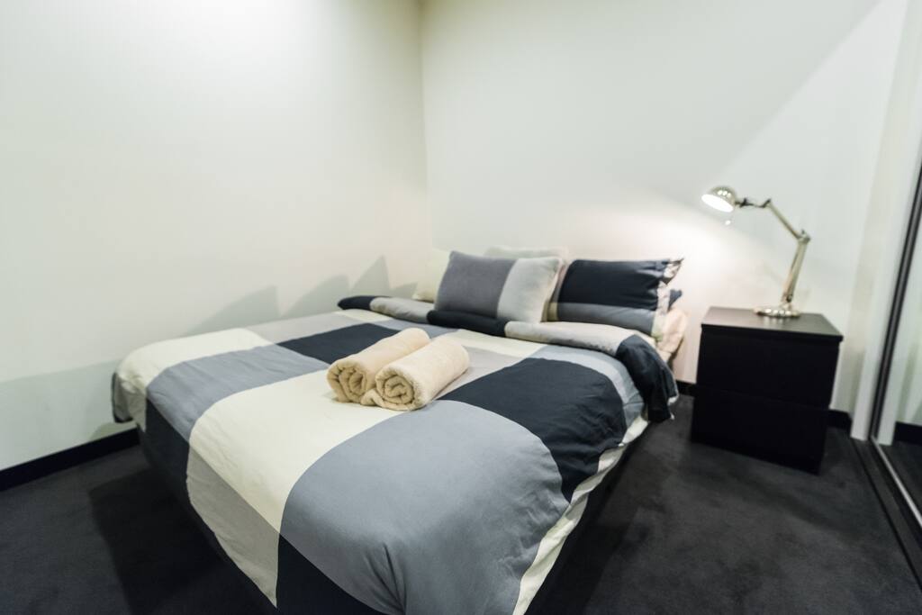 A bedroom with a queen sized bed & plush pillows...