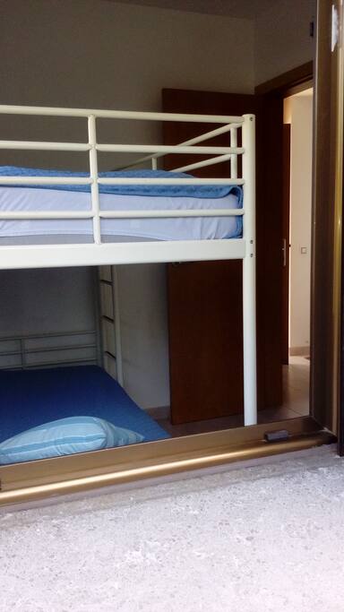 Habitación 1, con litera y posible colchón en el suelo o cama de 70cm. Guardarropa. Mesa y silla. Con ventanas al jardín Habitaciones confortables Sant Cugat del Vallés 1