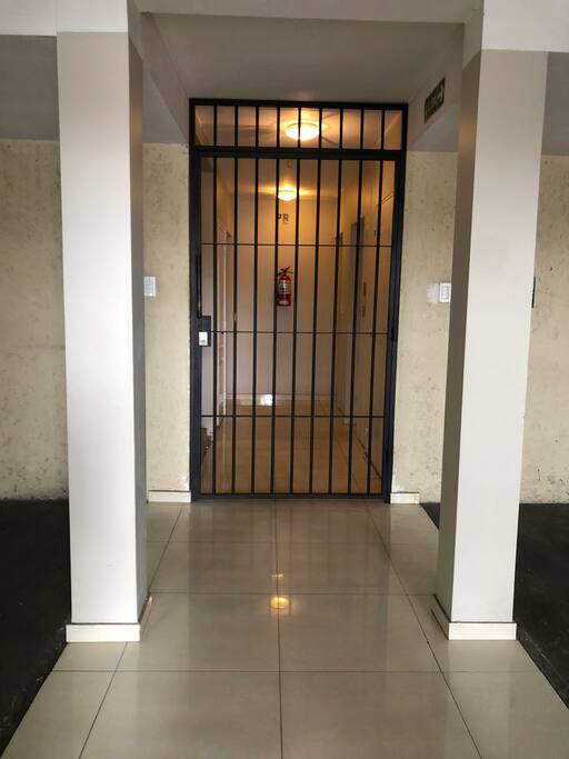 Tiene doble puerta, dentro del edificio encontrarás esta reja.