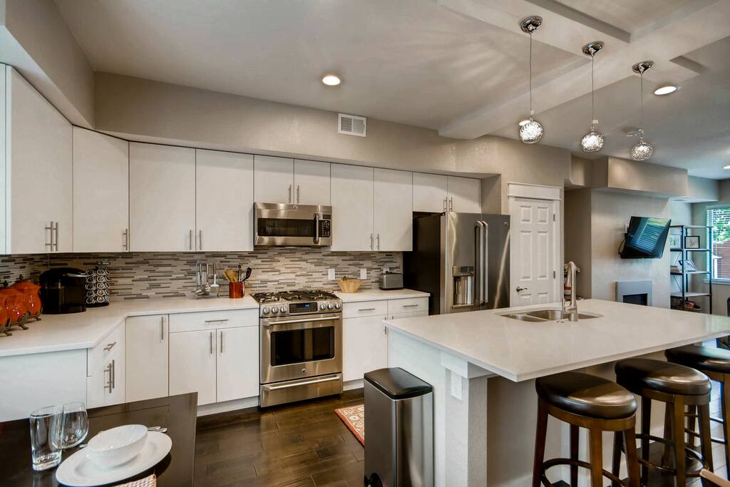 The lovely gourmet kitchen includes stainless-steel GE Cafe appliances, a Keurig, a teapot, a toaster, and a blender.