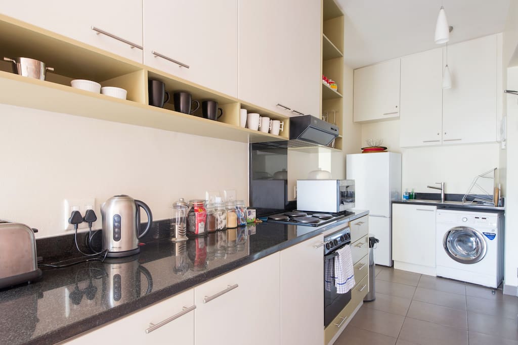Fully-equipped kitchen with all appliances including washing machine.