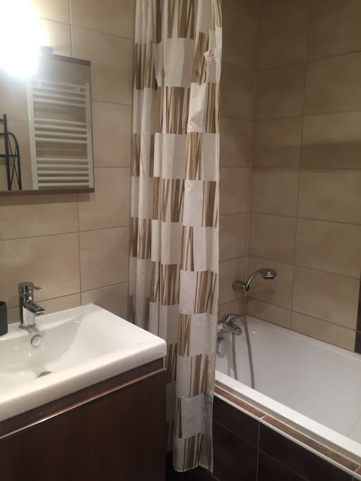 Salle de bain moderne avec baignoire .sèche cheveux à disposition.