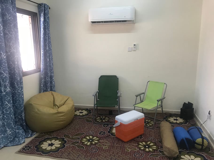 Sitting area with the camping gear that is provided for camping trips during your period of stay: cool box, chairs, tent, mattress and sleeping bags