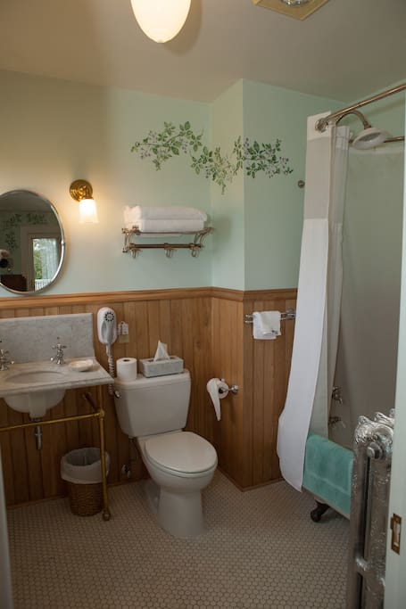 En suite bathroom with claw-foot tub and shower.