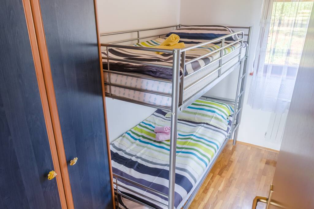 This is the small bedroom with a bunk bed, closet and window that overlooks olive trees and the woods.