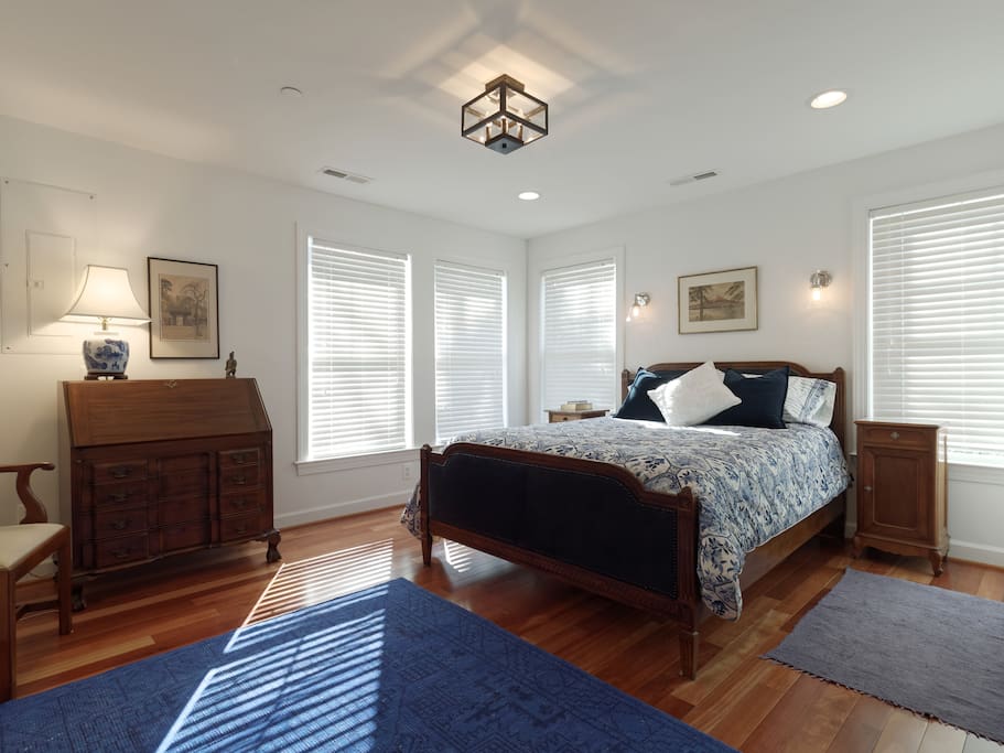 Master bedroom with queen bed, slant front antique desk, chair and double closets