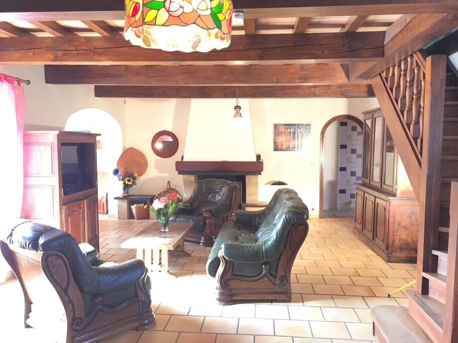 Salon séjour de 70m2 .1 canapé et 2 fauteuils cuir. table de salon et Tv écran plat.