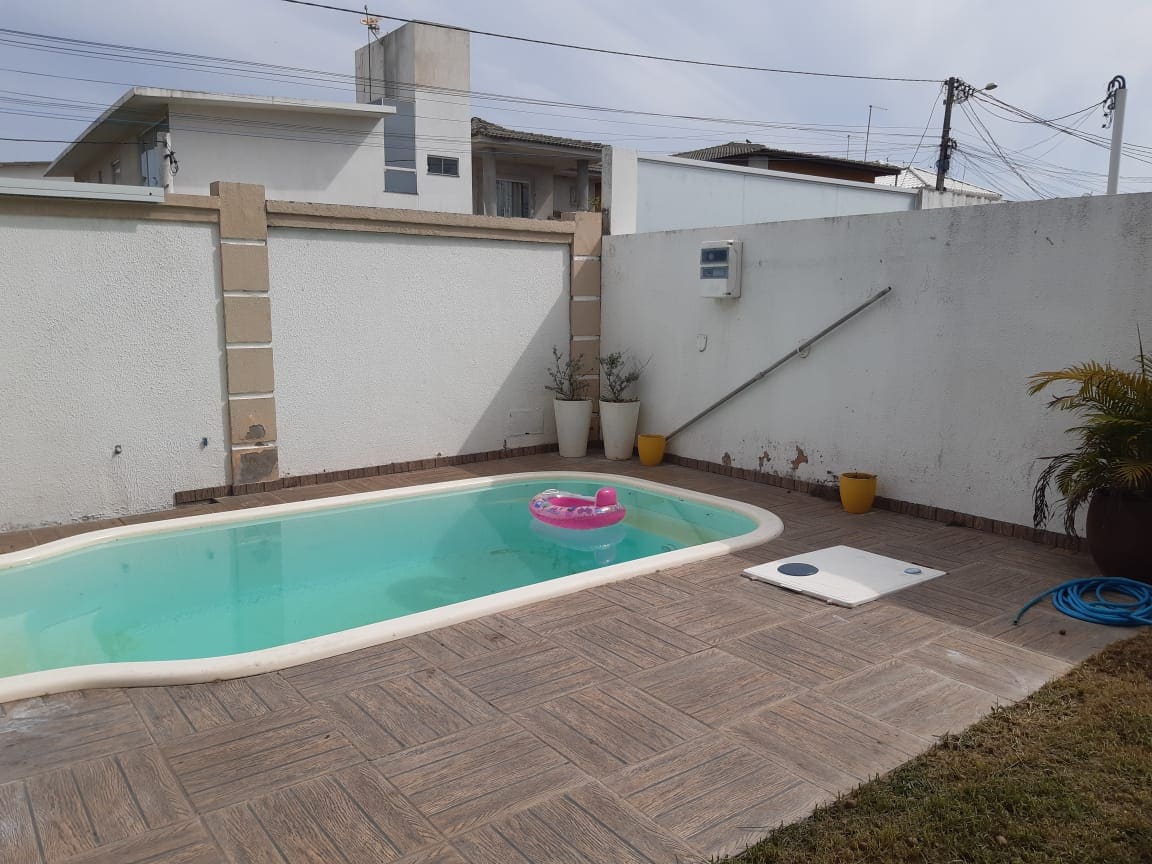 The outdoor area features a private pool, with a floating toy resting on the water. Surrounding the pool, a tiles deck provides ample space for relaxation. Potted plants are positioned near the pool, contributing to the serene environment.